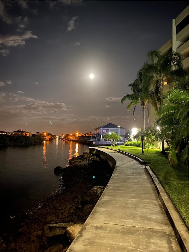 exterior space featuring a lawn and a water view