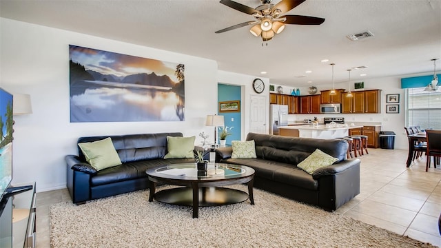 living room with ceiling fan and light tile patterned flooring