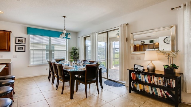 dining space with a notable chandelier and light tile patterned flooring