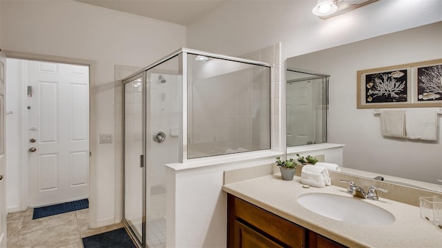 bathroom with a shower with shower door, vanity, and tile patterned flooring