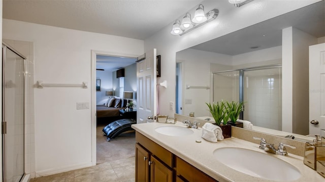 bathroom featuring an enclosed shower, dual bowl vanity, and tile patterned flooring