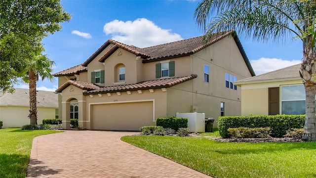 mediterranean / spanish-style home with a front yard and a garage