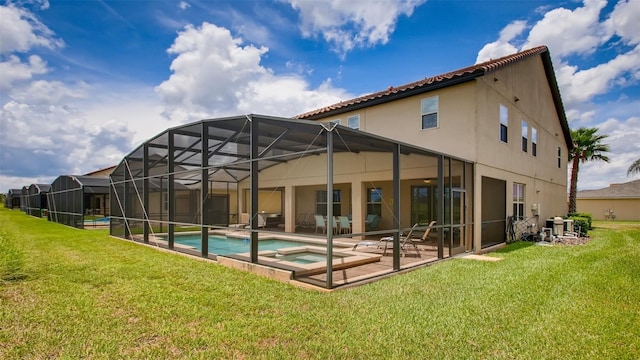 back of property featuring a fenced in pool, a patio area, a lanai, and a lawn