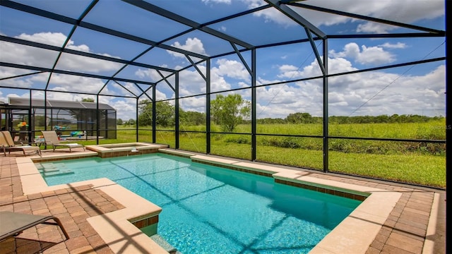 view of pool featuring glass enclosure, an in ground hot tub, and a patio area