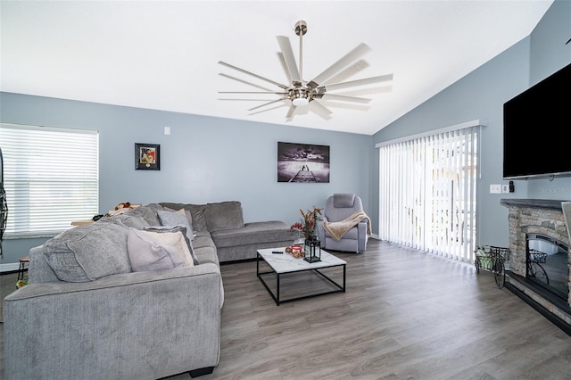 living room with a fireplace, plenty of natural light, ceiling fan, and hardwood / wood-style flooring