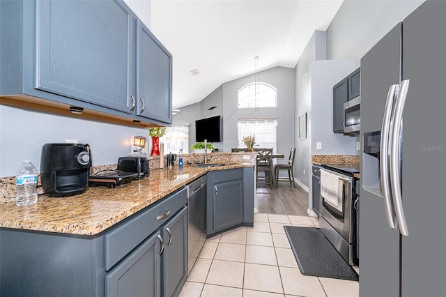 kitchen with appliances with stainless steel finishes, light hardwood / wood-style floors, light stone countertops, lofted ceiling, and kitchen peninsula