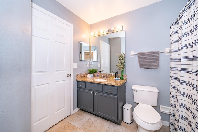 bathroom with toilet, vanity, and tile patterned floors