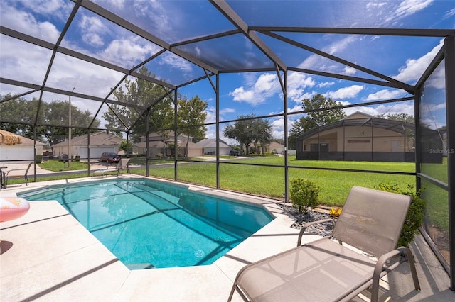 view of pool featuring a lawn, glass enclosure, and a patio area