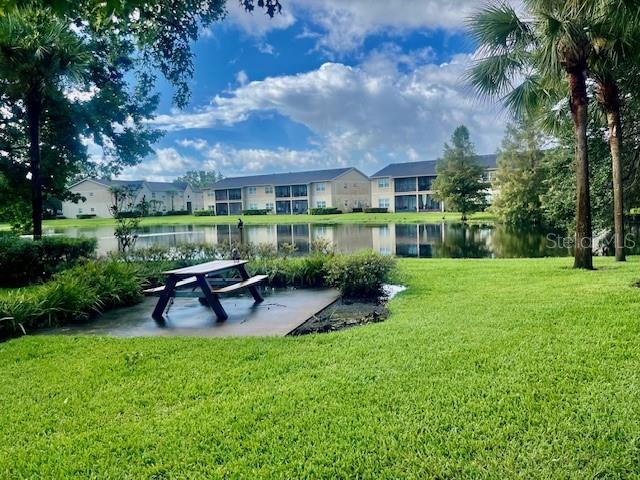 view of property's community with a yard, a water view, and a residential view