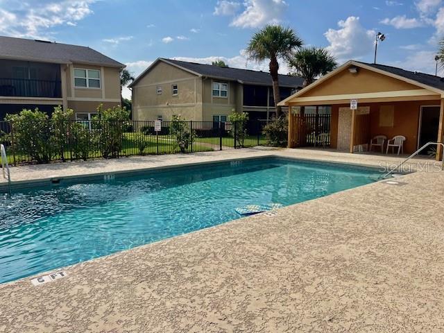 community pool featuring a patio area and fence