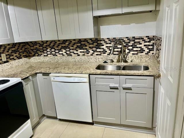 kitchen featuring tasteful backsplash, electric range oven, dishwasher, light stone countertops, and a sink