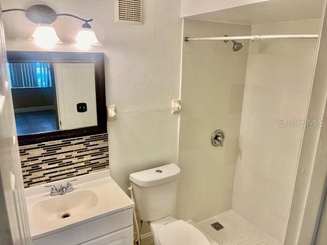 full bath with visible vents, a shower, decorative backsplash, toilet, and vanity