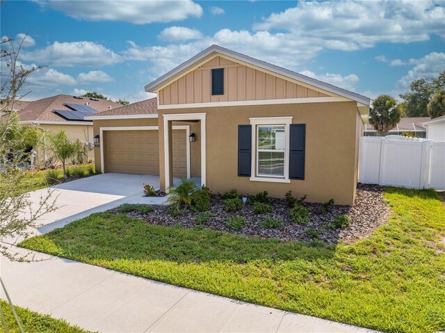 view of front of property with solar panels, a garage, and a front yard