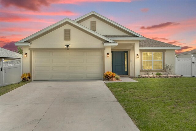 view of front of property featuring a garage and a yard