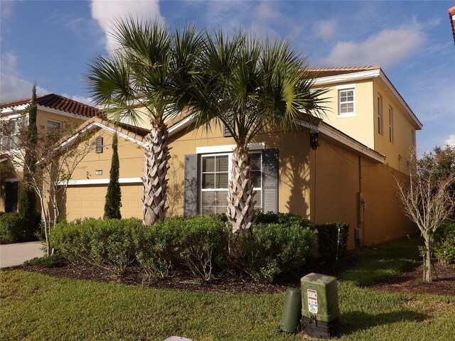 5265 Oakbourne Ave, Davenport, FL 33837 - view of property exterior with stucco siding, a garage, and a yard