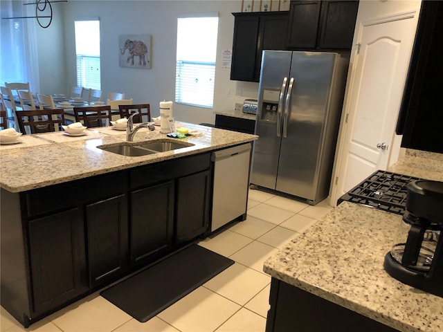 kitchen featuring a kitchen island with sink, sink, and stainless steel appliances