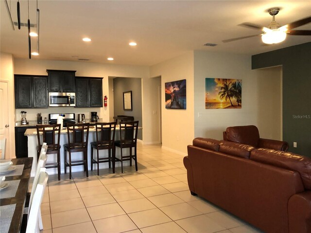 5265 Oakbourne Ave, Davenport, FL 33837 - living room featuring light tile patterned flooring, ceiling fan, recessed lighting, and baseboards