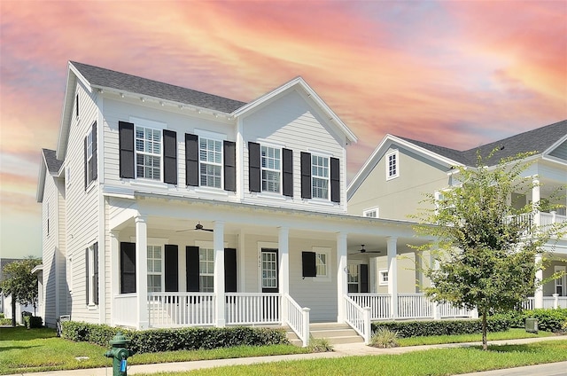 view of front facade featuring ceiling fan, a yard, and covered porch