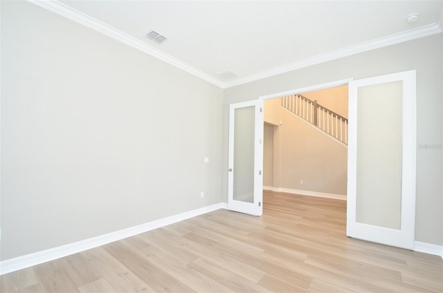 unfurnished room with crown molding, light hardwood / wood-style floors, and french doors