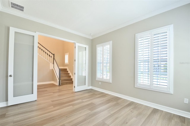 unfurnished room with ornamental molding, light hardwood / wood-style floors, and french doors