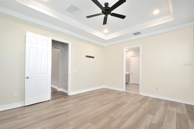 unfurnished bedroom featuring ceiling fan, a raised ceiling, crown molding, and light wood-type flooring