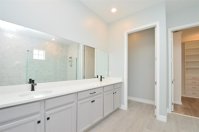 bathroom with dual vanity, a shower with door, and tile patterned floors