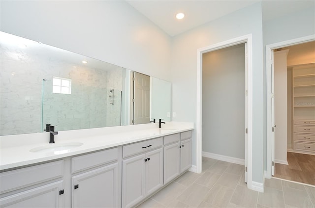 bathroom with vanity and a tile shower