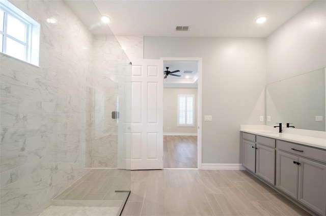 bathroom with ceiling fan, tile patterned floors, vanity, and tiled shower