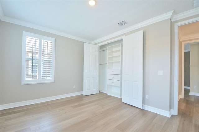 unfurnished bedroom featuring a closet, ornamental molding, and light wood-type flooring