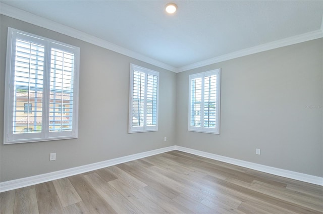 spare room with light hardwood / wood-style floors and crown molding