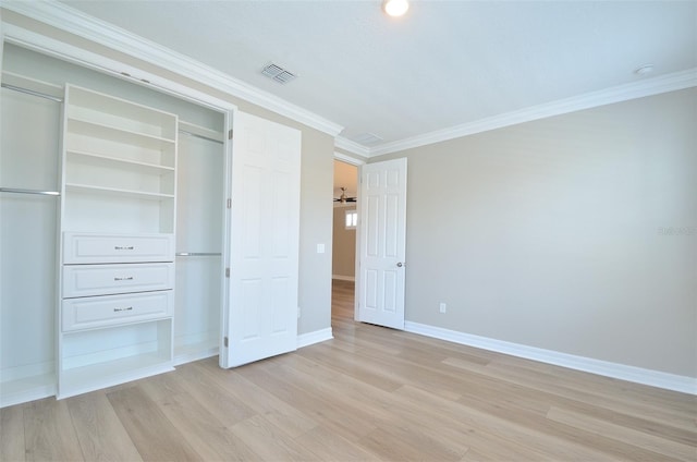 unfurnished bedroom with ornamental molding, a closet, and light wood-type flooring