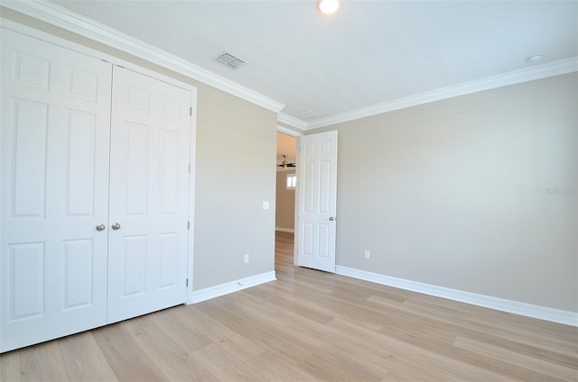 unfurnished bedroom featuring light hardwood / wood-style floors, ornamental molding, and a closet