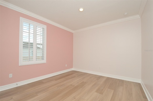 spare room featuring crown molding and light hardwood / wood-style floors