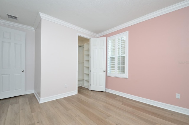 unfurnished bedroom featuring light wood-type flooring and crown molding