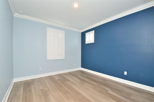 empty room featuring light wood-type flooring and crown molding