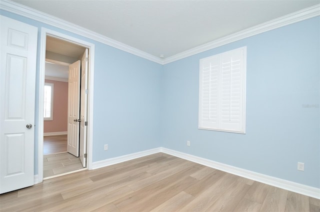 empty room with light hardwood / wood-style flooring and ornamental molding