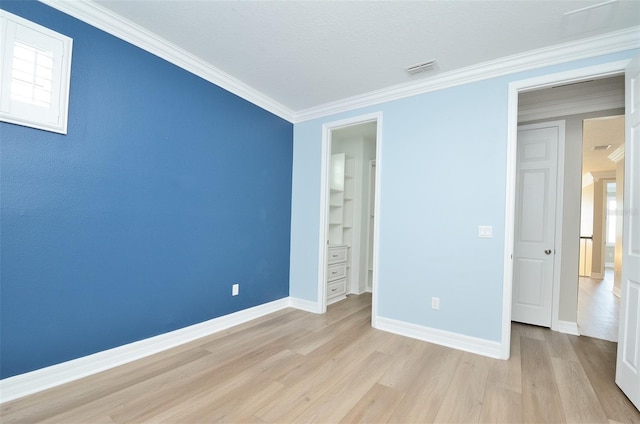 unfurnished bedroom featuring crown molding and light wood-type flooring