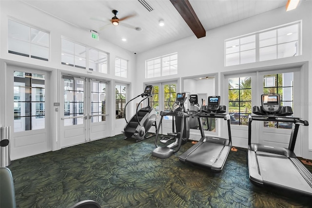 gym with a high ceiling, dark colored carpet, ceiling fan, and french doors