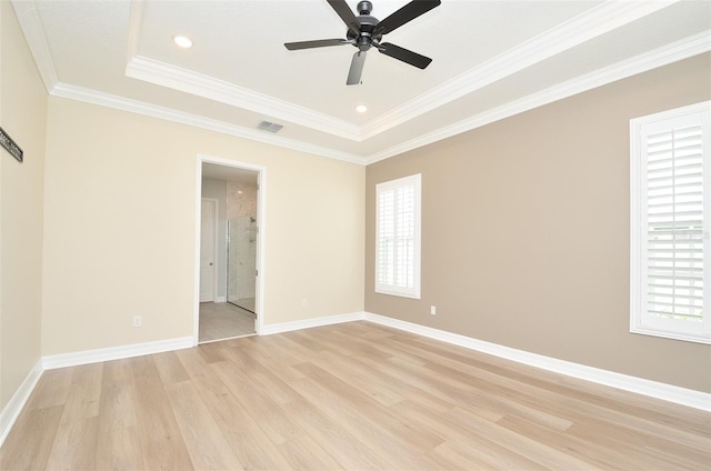 spare room with crown molding, a raised ceiling, ceiling fan, and light wood-type flooring