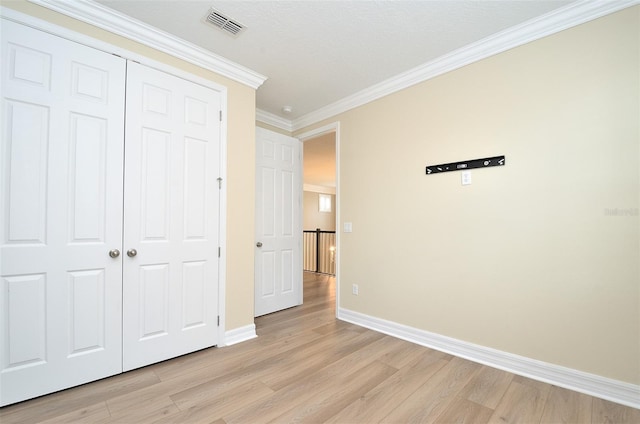 1862 Beach Ridge Rd, Celebration, FL 34747 - unfurnished bedroom with light wood finished floors, baseboards, ornamental molding, and a closet