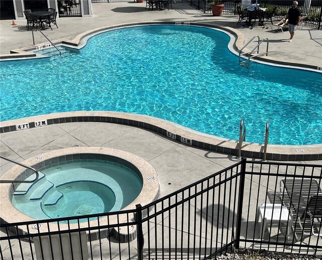 view of pool featuring a patio area and a community hot tub