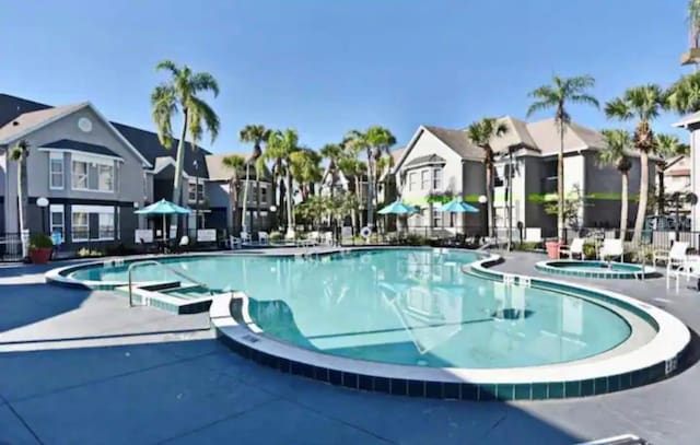 view of swimming pool featuring a hot tub