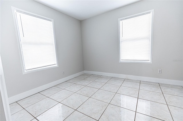 unfurnished room with plenty of natural light and light tile patterned floors