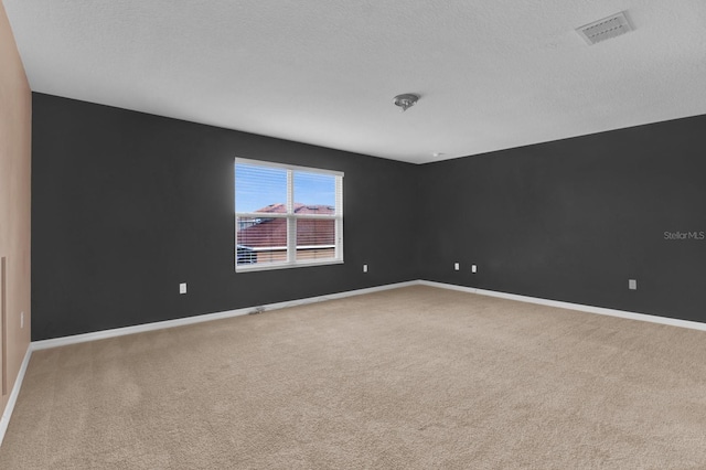 carpeted spare room with a textured ceiling