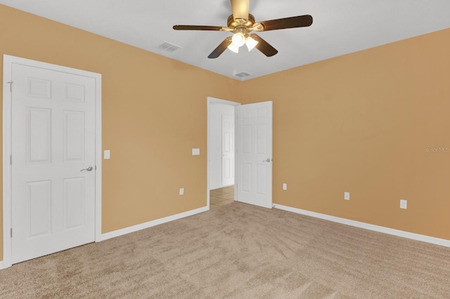 spare room featuring light colored carpet and ceiling fan