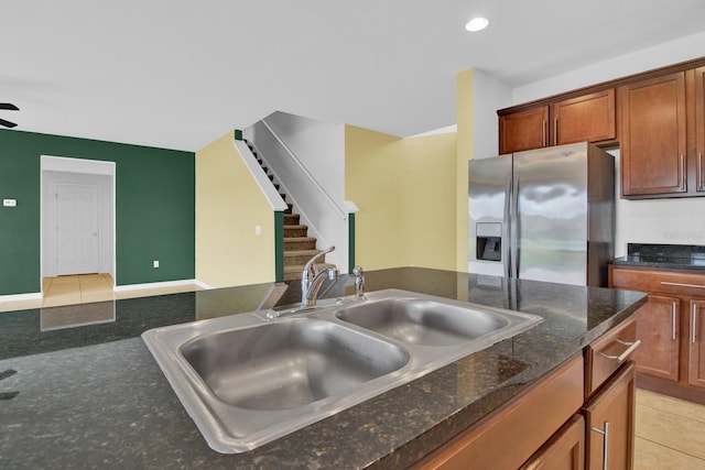 kitchen with stainless steel refrigerator with ice dispenser, sink, and light tile patterned floors