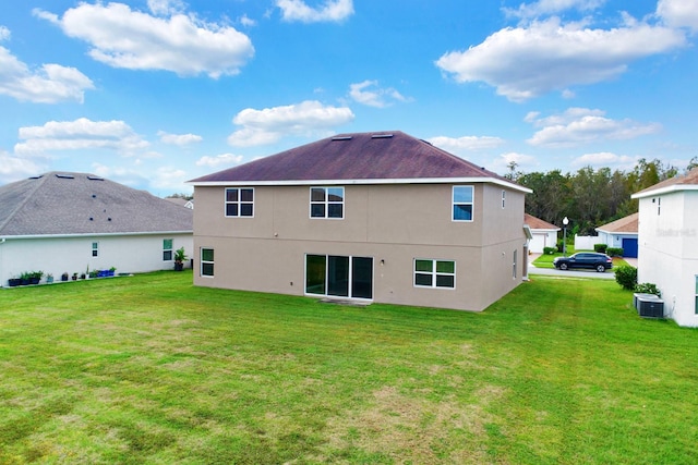 back of property with central AC and a yard