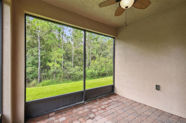 unfurnished sunroom with ceiling fan and a healthy amount of sunlight