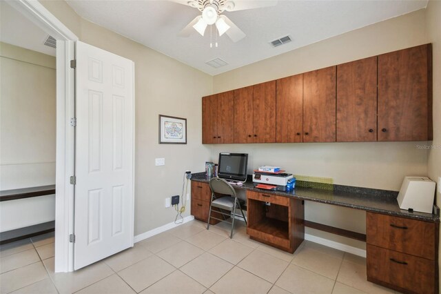 tiled office space with built in desk and ceiling fan