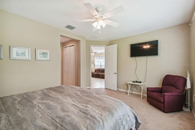 bedroom featuring ceiling fan, a closet, and light carpet